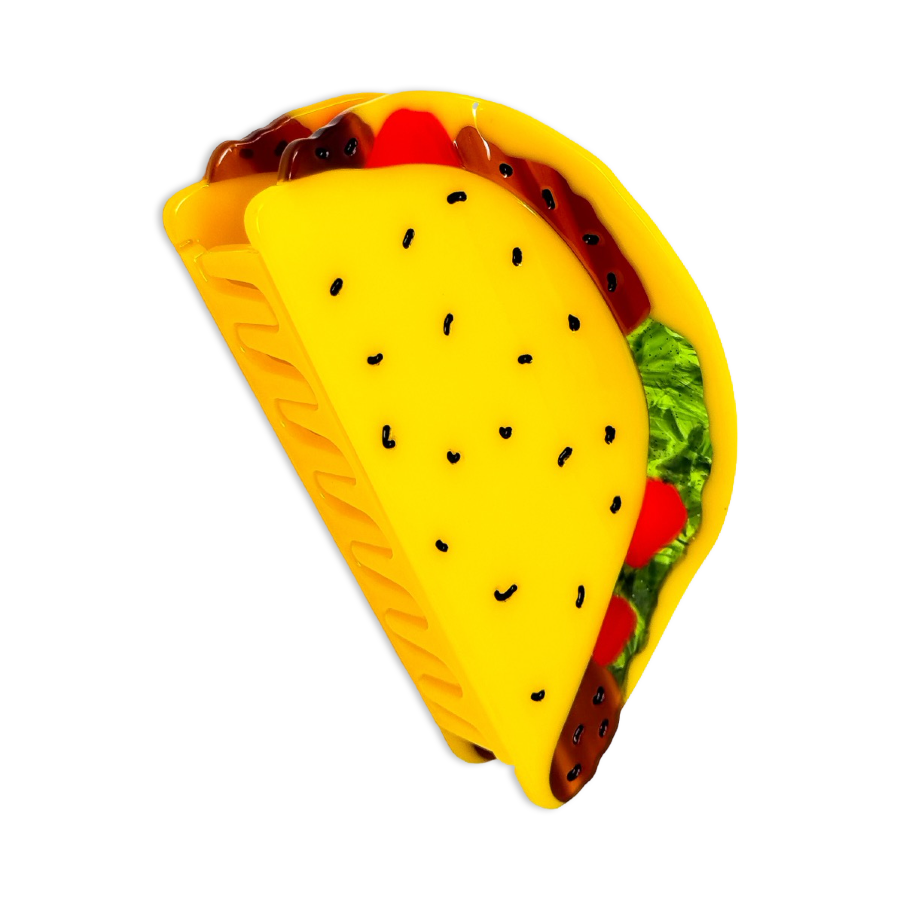 Yellow taco-shaped hair clip with visible ingredients on a white background
