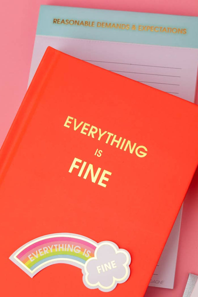 Orange book titled 'Everything is Fine' with a rainbow sticker on a pink background