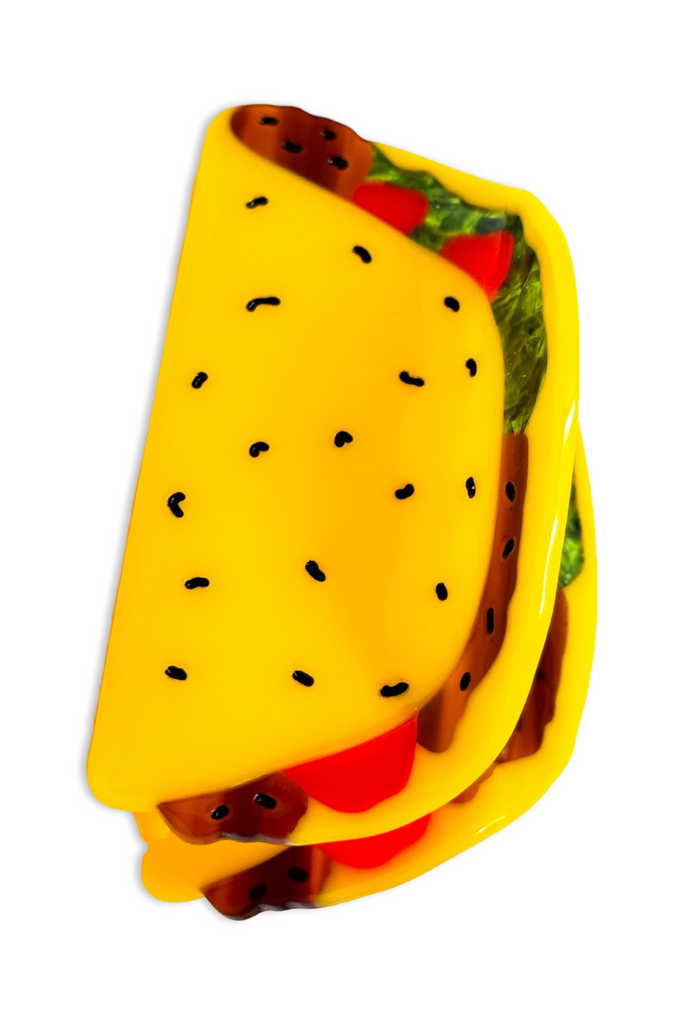 Yellow plastic taco shell hair accessory clip on a white background