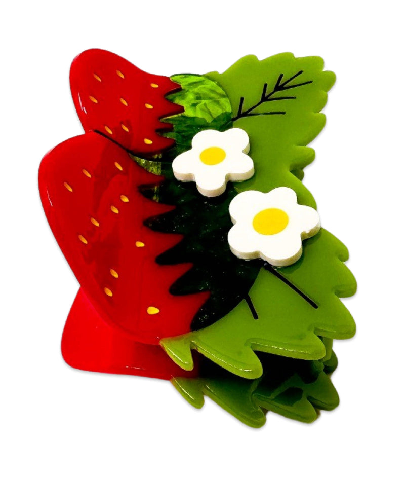 Red strawberry hair clip with green leaves and white flowers on a white background