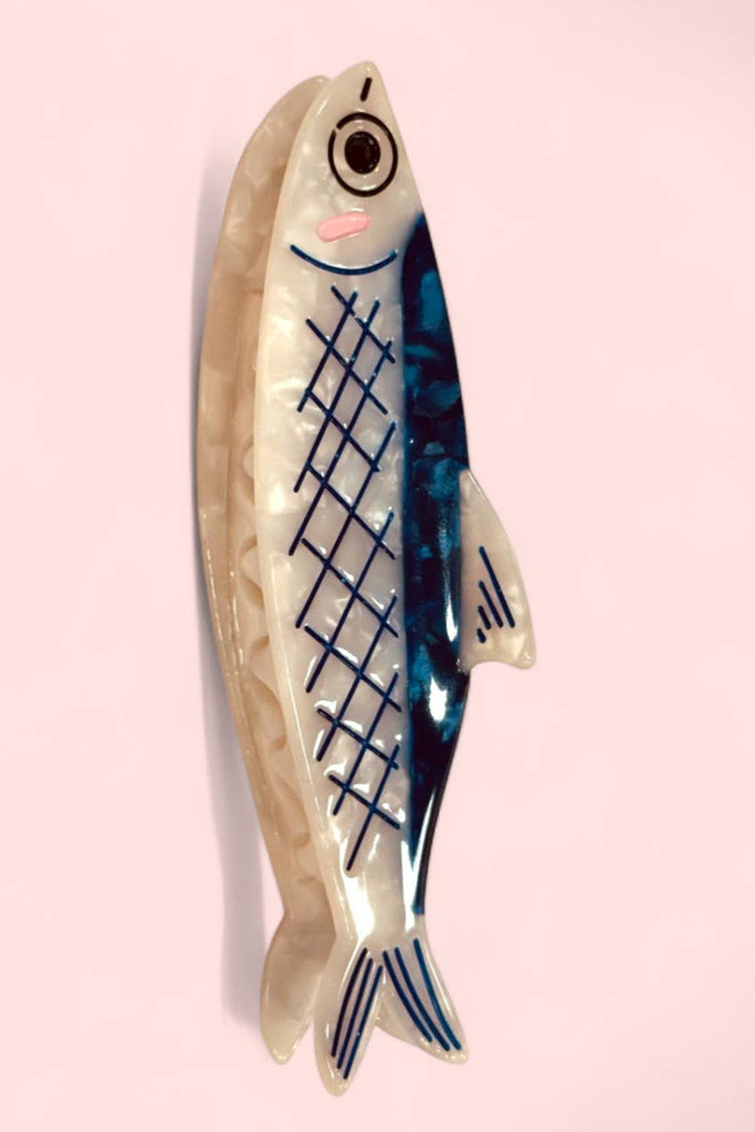 A blue and white hair clip designed to resemble an anchovy fish.