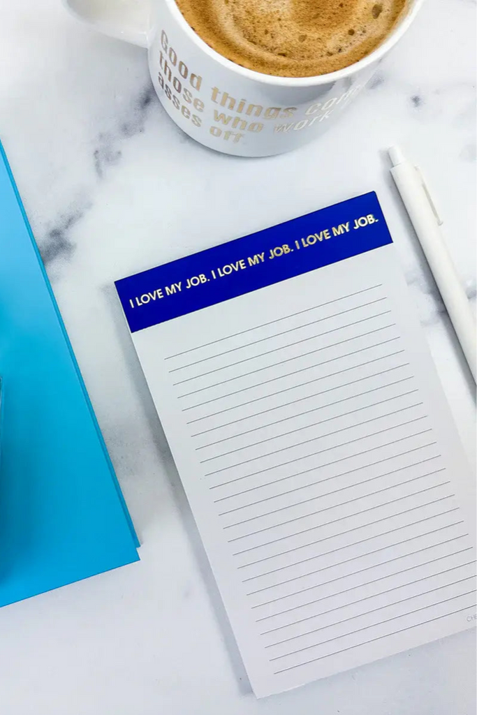 Notebook, notepad, and coffee cup on a marble surface