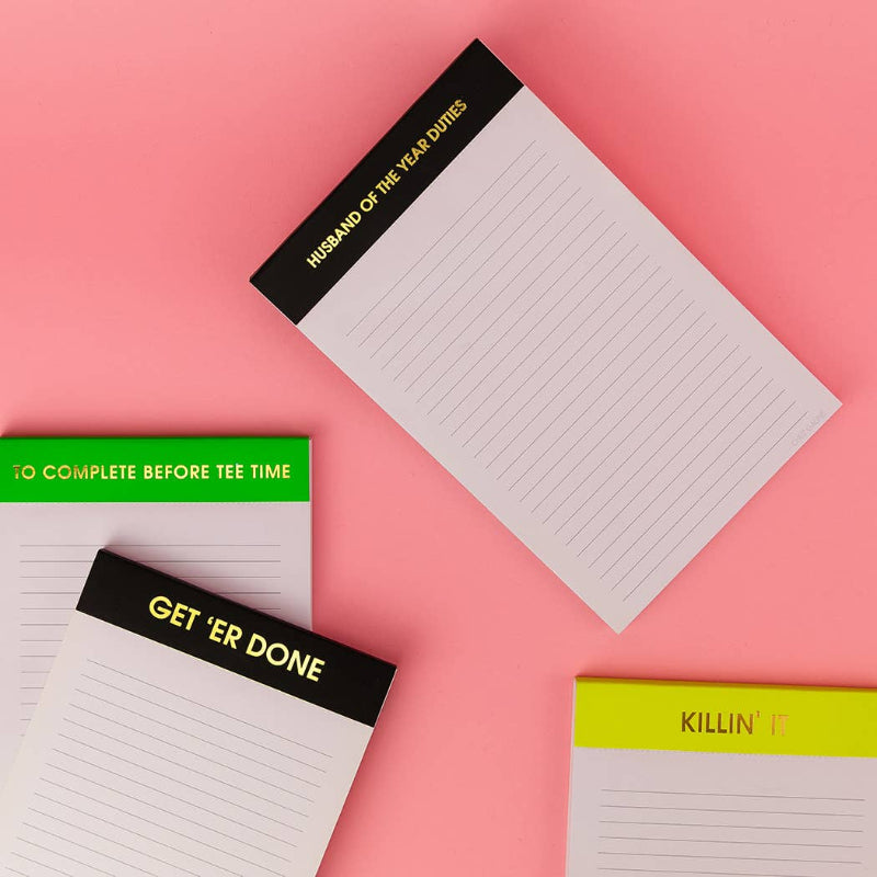 Four notepads with different sayings on a pink background