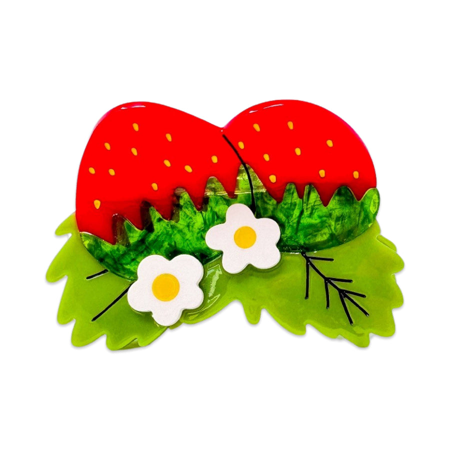Strawberry-themed hair clip with red strawberries, green leaves, and white flowers on a white background