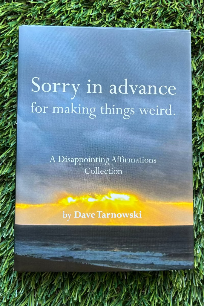 Book titled 'Sorry in advance for making things weird' by Dave Tarnowski on grass