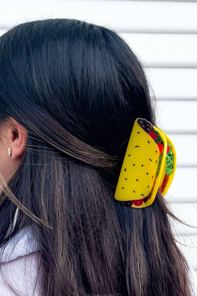 Person with a colorful hair clip in their hair against a white background