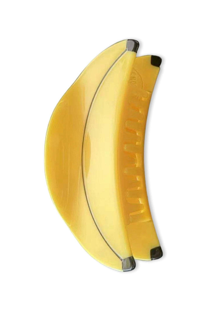 Yellow banana-shaped hair clip on a white background