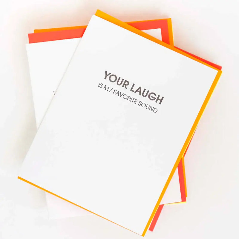 Notebook with 'Your laugh is my favorite sound' text on a light background