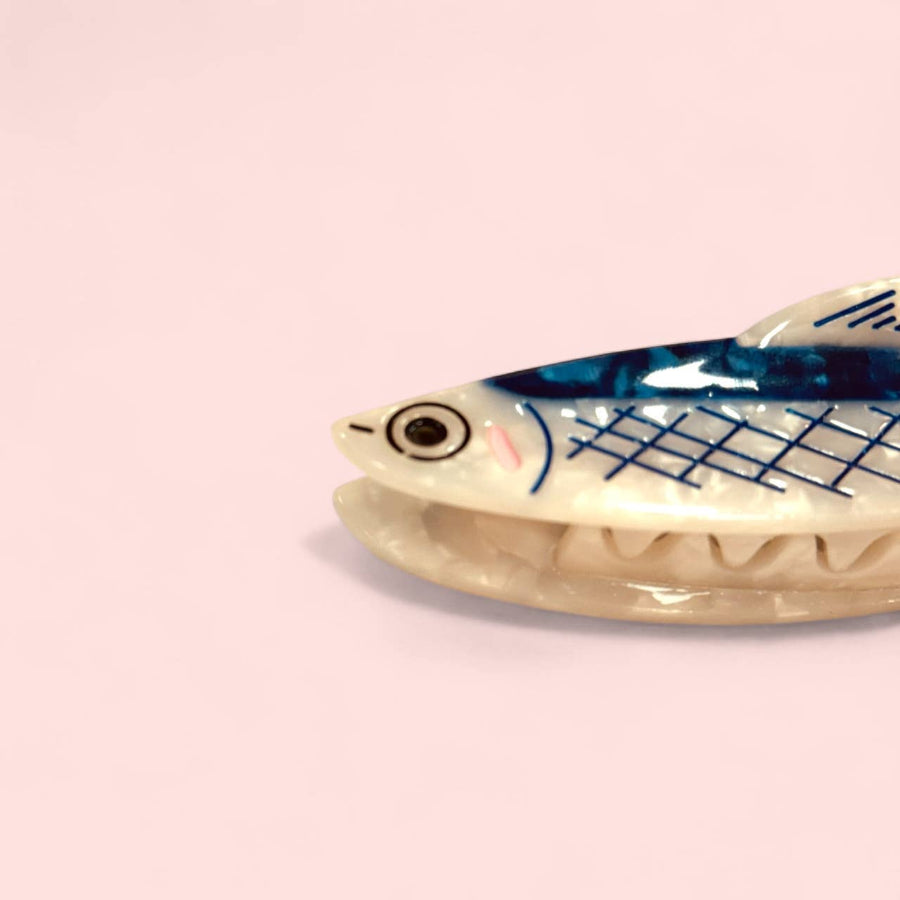 Fish-shaped anchovy hair clip with blue pattern on pink background