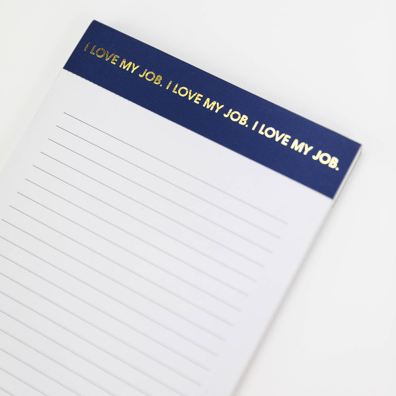 Notepad with 'I LOVE MY JOB.' text on a blue strip